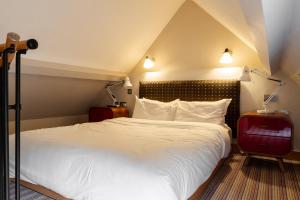een slaapkamer met een groot wit bed met 2 lampen bij The Vineyard Lamberhurst in Lamberhurst