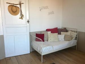 a crib with pillows on it in a room at Le logis blanc bed&breakfast in Coursan