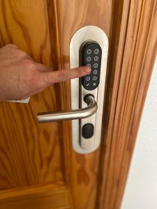 een hand ontgrendelt een deur met een afstandsbediening bij Hostal Pensimar in El Altet