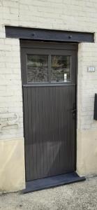 a black garage door with a window on a building at chez pépé Victor in Bouillon