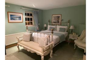 a bedroom with two beds and a couch and a chair at OYO The Leven in Stokesley