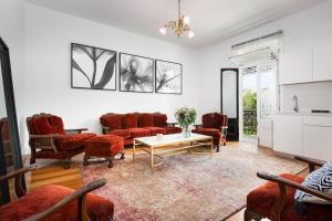 a living room with red chairs and a table at Executive Studio with Patio Near Trains in Sydney