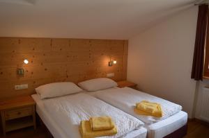 ein Schlafzimmer mit einem Bett mit zwei gelben Handtüchern darauf in der Unterkunft Chalet Regina in Wolkenstein in Gröden