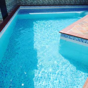 una piscina de agua azul y una acera en Cosmos Tatacoa Hotel, en Villavieja