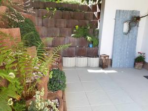 a garden with a retaining wall and a patio at Ferienwohnung Poth in Zwingenberg