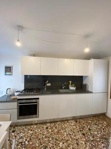 una cucina con armadietti bianchi e piano cottura di Ca' Berto Apartment a Venezia