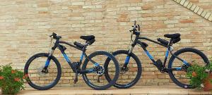 two bikes are parked next to a brick wall at Il Giardino Degli Ulivi in Appignano