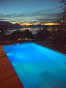 a blue swimming pool with a view of the water at Lirolay apartments in San Carlos de Bariloche