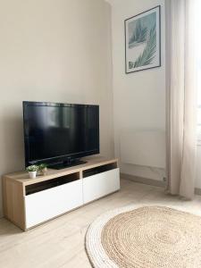 a living room with a flat screen tv on a white cabinet at Chaleureux Studio 30m2 - Au pied de la Gare - PARKING in Cergy