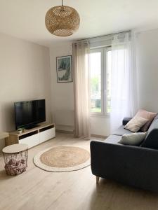 a living room with a couch and a tv at Chaleureux Studio 30m2 - Au pied de la Gare - PARKING in Cergy