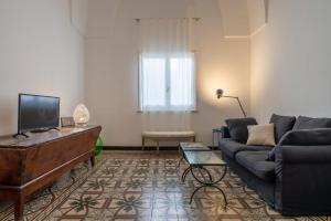 ein Wohnzimmer mit einem Sofa und einem TV in der Unterkunft Italianway - Le Cementine in Lecce