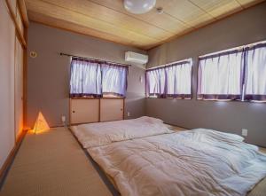 a large bed in a room with two windows at Yasuo-shiki Ishigaki-tei #HH5x in Toyama