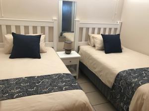 2 bedden in een hotelkamer met 2 eenpersoonsbedden bij 111 Lescalier Cabanas - Amanzimtoti in Amanzimtoti