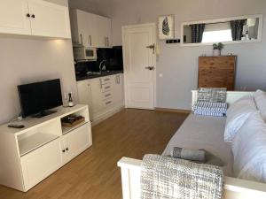 a bedroom with a bed and a tv and a kitchen at Estudio Edificio Almirante in Mijas Costa