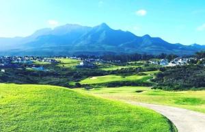 vistas a un campo de golf con montañas de fondo en 51 Trafford en George