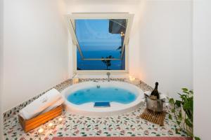 a bath tub in a bathroom with a window at Grand Hotel Tritone in Praiano