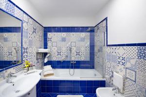 a blue tiled bathroom with a tub and a sink at Grand Hotel Tritone in Praiano