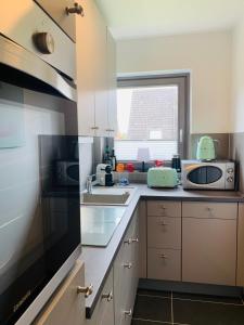 a kitchen with a sink and a microwave at Ferienwohnung Syltliebe in Wenningstedt