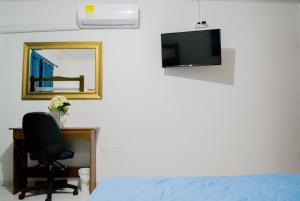 um quarto com uma cama, uma secretária e um espelho em Hotel Ocean View em Cartagena das Índias