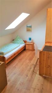 Schlafzimmer mit einem Bett, einem Schreibtisch und einem Fenster in der Unterkunft Ferienwohnung Sommerwind in Rhauderfehn