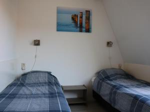 Un dormitorio con dos camas y un cuadro en la pared. en DortDomburg, en Domburg