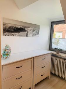 a kitchen with a dresser and a painting on the wall at Ferienwohnung Syltliebe in Wenningstedt