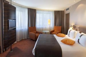 ein Hotelzimmer mit einem großen Bett und einem TV in der Unterkunft Holiday Inn Almaty, an IHG Hotel in Almaty