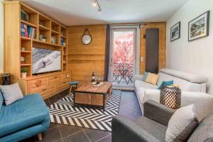 ein Wohnzimmer mit 2 Sofas und einem TV in der Unterkunft Le Paradis 25 Apartment - Chamonix All Year in Chamonix-Mont-Blanc