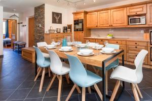 eine Küche mit einem Holztisch und Stühlen in der Unterkunft Le Paradis 25 Apartment - Chamonix All Year in Chamonix-Mont-Blanc