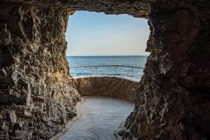 a view of the ocean through a stone wall at Grand Hotel Tritone in Praiano
