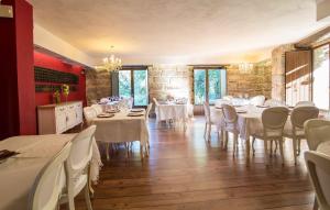 a dining room with tables and chairs and a stone wall at A Aira da Petada Hotel Boutique in Corzos