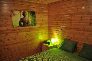 ラ・ロシュ・アン・アルデンヌにあるLes Rochettes - Vénus 1の木製の壁のベッドルーム(ベッド1台、ランプ付)