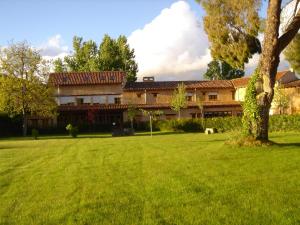 a house with a green lawn in front of it at El Jardin de la Huerta in Sahagún