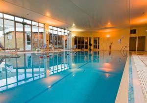 a large swimming pool in a large building at Holiday Inn Ipswich, an IHG Hotel in Ipswich