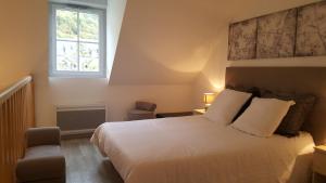 a bedroom with a white bed and a window at La Pépite in Luchon