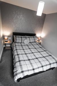 Un dormitorio con una cama con una manta a cuadros. en No 3 New Inn Apartments, en Newark-on-Trent