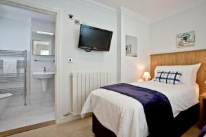 a bedroom with a bed and a tv on the wall at 3 Goodrington Lodge, Paignton in Paignton +18 photos