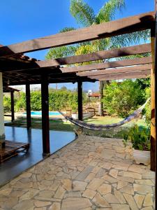 un patio con una hamaca y una piscina en Casa de Temporada em Capitólio (Charme e Aconchego), en Capitólio