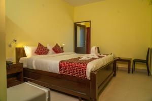 um quarto com uma cama e um espelho em VGR-HOMESTAY em Kodaikanal