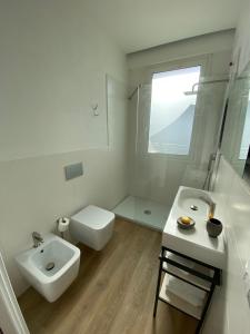a white bathroom with a sink and a toilet at Residenza Acqva di Mare in Cagliari