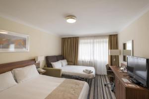 a hotel room with two beds and a television at Holiday Inn Norwich, Ipswich Road, an IHG Hotel in Norwich