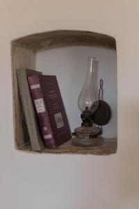 a shelf with books and a lamp on it at Παραδοσιακή κατοικία Μαργαρίτες in Margarítai