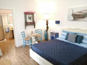 una camera con letto blu e tavolo e sedie di Borgo Salentino a San Vito dei Normanni