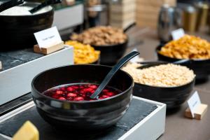 a counter with bowls of cranberries and other food at voco St. Johns Solihull, an IHG Hotel in Solihull