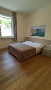 a bedroom with a large bed and a large window at B&B Via delle 5 Terre in La Spezia