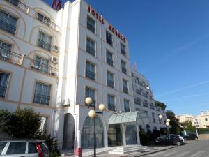 a white building with a sign on the front of it at Hotel Monaco in Faro