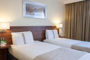 um quarto de hotel com duas camas e duas lâmpadas em Holiday Inn Rugby-Northampton M1 Jct18, an IHG Hotel em Crick