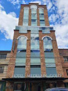 
a tall brick building with a clock on the front of it at Hotel Medellín Gold in Medellín
