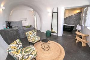 - un salon avec une table, des chaises et une baignoire dans l'établissement Luxury Santorini Villa Villa Elysian Dyo Private Hot Tub Air Conditioning 1 Bedroom Oia, à Foinikiá
