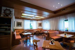 un ristorante con tavoli, sedie e finestre di Hotel Rio a Caderzone